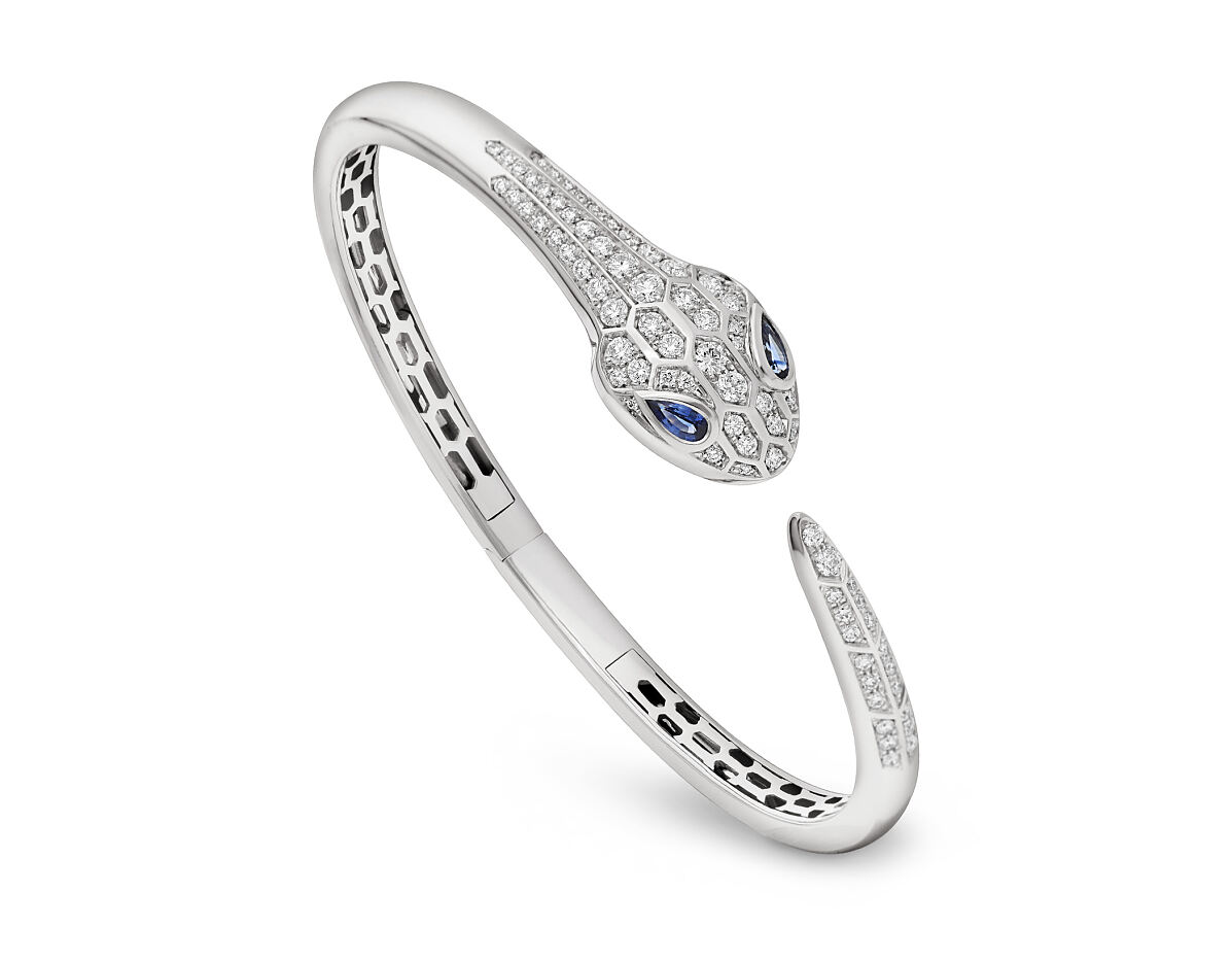 Serpenti 18 kt white gold bangle bracelet set with blue sapphire eyes and demi pavé diamonds on the head and tail.